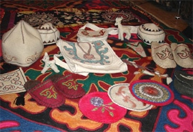 Felt purses, slippers, hats, coasters, and stuffed animals that Rakhat’s mother made. On the bottom, you can see the rug that she made for the young couple.