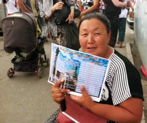 Woman selling the "azan" schedule at Osh Bazaar, which changes everyday, so Muslims know when to eat breakfast and dinner.