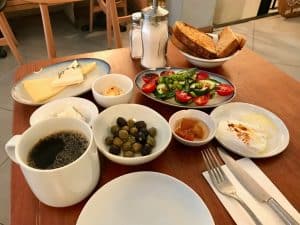 Turkish Breakfast with Bergamotsh Jam, Poached Egg, Cheese, Chili Butter, Olives and Lor Curd Cheese Served with Tea / Coffee at Restaurant.